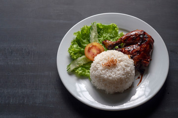 Grilled chicken leg with rice on a plate