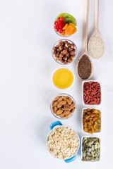 Bowl with ingredients for cooking  homemade granola on white background. Healthy snak. flat lay