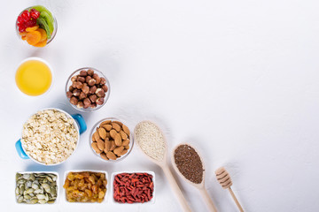 Bowl with ingredients for cooking  homemade granola on white background. Healthy snak. flat lay