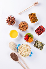Bowl with ingredients for cooking  homemade granola on white background. Healthy snak. flat lay