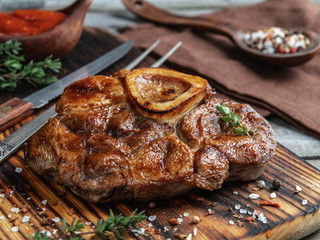 Prepared Osso buco Veal shank on a portion board closeup