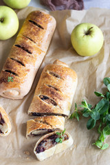Traditional apple strudel with raisin and cinnamon on grey concrete background. Copy space.