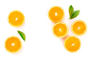 An overhead photo of orange halves and green leaves, shot from the top on a white background, forming a frame for copy space