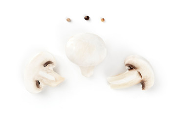 Fototapeta na wymiar Three champignon mushrooms, shot from the top on a white background with pepper, a flatlay composition with copy space