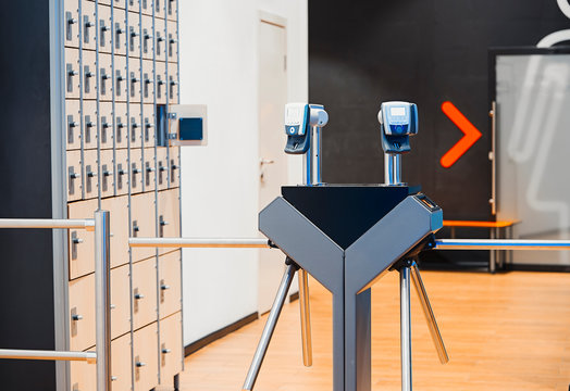 Fingerprint scanners at the entrance in modern bright gym and Lockers.