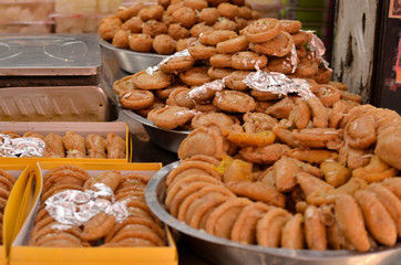 Close up shot of ghujia decorated and displayed in a big plate and in boxes in a sweet shop . Ghujia is a popular Indian sweet dish prepared during the festival season of Holi in northern India.