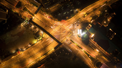 Aerial view of highway junctions shape letter x cross at night. Bridges, roads, or streets in transportation concept. Structure shapes of architecture in urban city, Kuala Lumpur Downtown, Malaysia