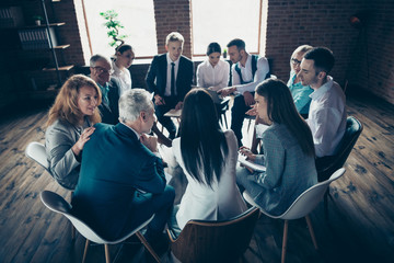 Fototapeta premium Nice classy elegant stylish attractive focused concentrated specialists sitting on chairs discussing financial corporate conference at modern industrial loft interior work place space