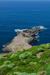 El Sauzal volcanic coastline, stone path and green vegetation, with blue Atlantic ocean, Tenerife, Canary islands, Spain
