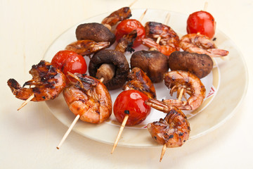 tomato, mushroom and king prawn kebabs on a plate