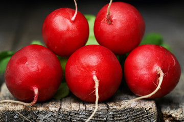 Red fresh radish on the edge of old rustic wooden table