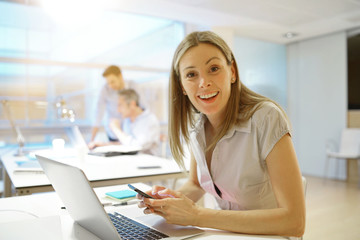 Smily businesswoman looking at camera in modern office