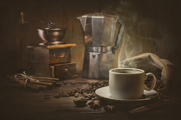 Coffee cup and coffee beans on a wooden table and dark background