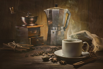 Coffee cup and coffee beans on a wooden table and dark background