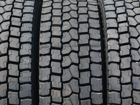 Stacked truck tyres under daylight.