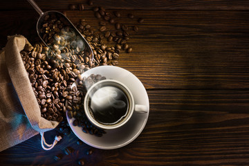 Coffee cup and coffee beans on wooden background. Top view. - Image