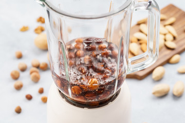 Blender with soaked hazelnuts for making nut milk.