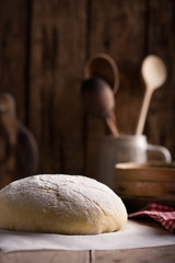 Dough and ingredients for it - eggs flour yeast on brown wooden background. Selective focus.