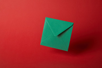 bright, colorful and green envelope on red background with copy space