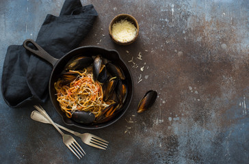 Spaghetti and mussels in an iron pan