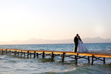 Wedding couple, bride, groom walking and posing on pier