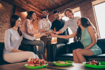 Close up photo having fun buddies anniversary event company hang out say toasts she her ladies he him his guys wineglasses golden beverage wear dresses shirts formalwear sit sofa loft room indoors