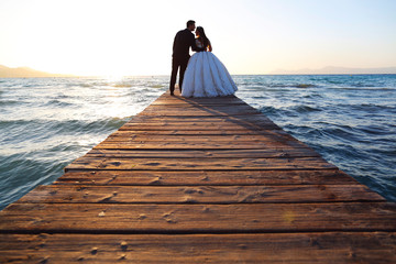 Wedding couple, bride, groom walking and posing on pier