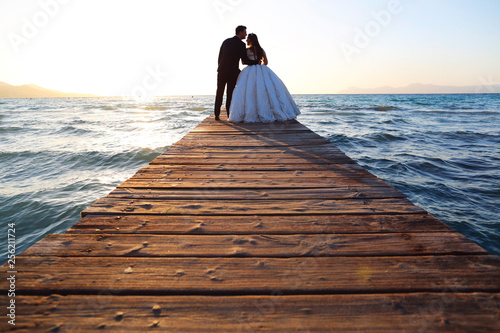 Wedding couple, bride, groom walking and posing on pier