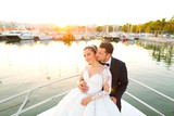 Beautiful wedding couple posing on boat at sea