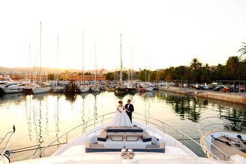 Wedding couple posing on boat at sunset