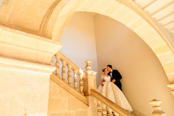 Bride and groom posing in old house on steps