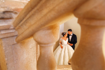 Bride and groom posing in old house on steps