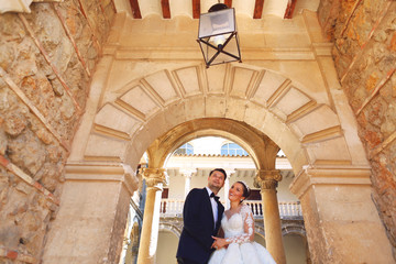 Beautiful wedding couple posing in old medieval house
