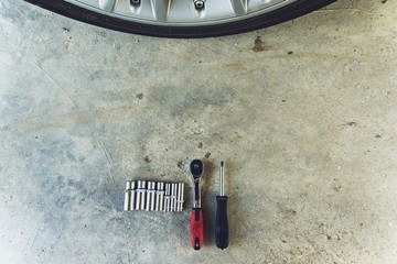 A car tools on concrete floor with wheel on background