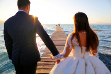 Wedding couple, bride, groom walking and posing on pier