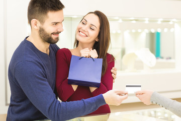 Happy loving couple buying jewelry at the jewelry store