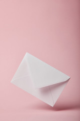 white and empty envelope on pink background with copy space