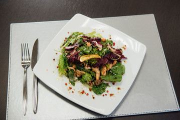Salad with shrimps and greens on a plate on the table