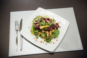 Salad with shrimps and greens on a plate on the table