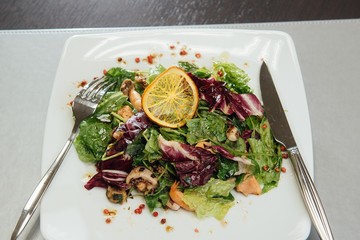 Salad with shrimps and greens on a plate on the table