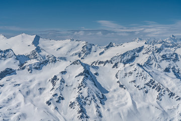 Fototapeta premium Switzerland, panorama view from Titlis mountain on Alps and mountains above white clouds