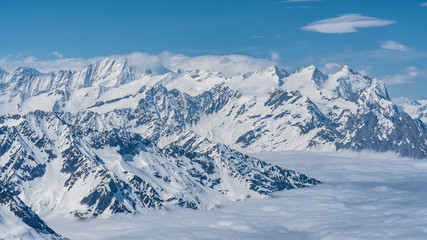 Naklejka premium Switzerland, panorama view from Titlis mountain on Alps and mountains above white clouds