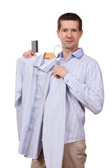 the man holds a coat hanger with a shirt and the plastic card on a white background