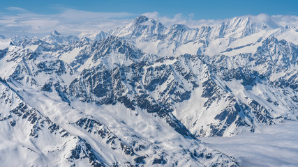 Switzerland, panorama view from Titlis mountain on Alps and mountains above white clouds