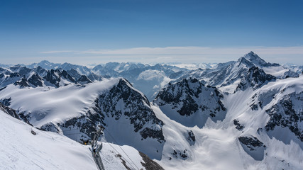 Fototapeta na wymiar Switzerland, panorama view from Titlis mountain on Alps and mountains above white clouds