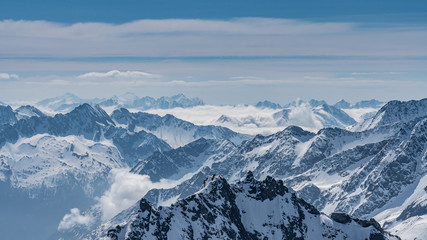 Fototapeta na wymiar Switzerland, panorama view from Titlis mountain on Alps and mountains above white clouds