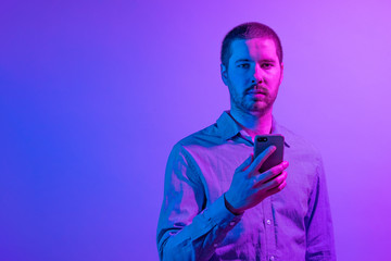 Serious businessman holding his mobile phone