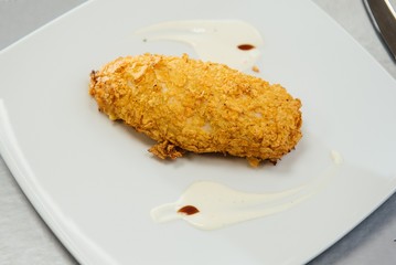 Chicken breast breaded on a plate on the table