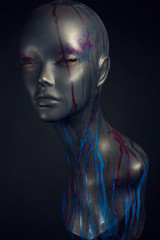 Closeup studio shot of colored woman mannequin with stylish decoration, dark background