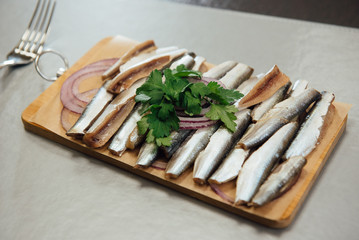 fresh sprat with greens on a cutting board on the table